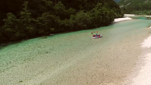 Aerial view of adventurers doing rafting and going down the Soca River.