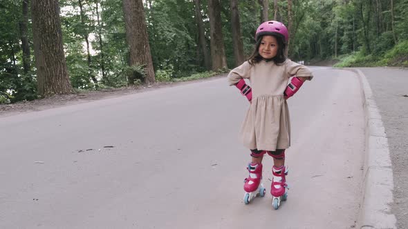 Cute Girl in Safety Equipment Is Standing on the Road