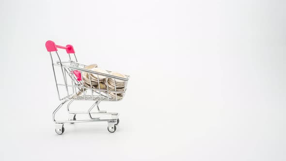 4k Stop motion of shopping cart with coin stack isolated on white background.