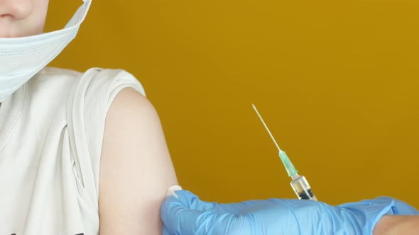 Close-up shot of a Caucasian school-age boy being given the vaccine.