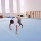 A Teenager Boy is Doing a Cartwheel and a Triple Back Flip in Gym Steadicam - VideoHive Item for Sale