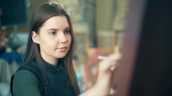 Artist Paints Picture on Canvas with Oil Paints in Her Workshop