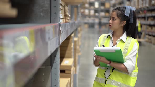 Woman warehouse worker doing stock taking of products management in cardboard box on shelves