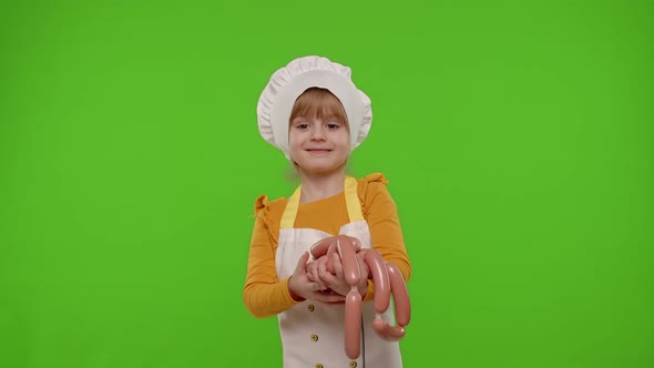 Child Girl Dressed in Apron Like Chef Cook Sniffing Sausages Recomending and Showing Them to Camera