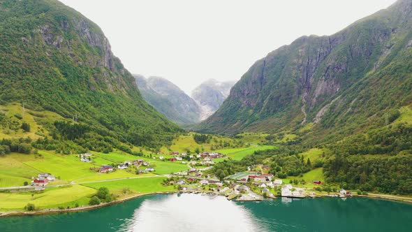 Beautiful town between mountains on the shore of a stunning Lake - Aerial footage