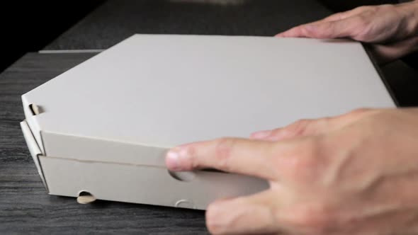 Opening a Paper Box with Freshly Cooked Pizza Closeup