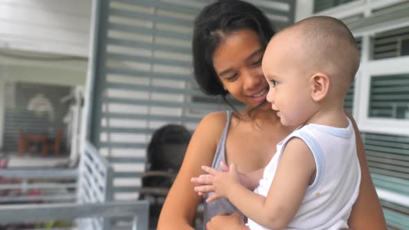 Cheerful Asian Mother with Mixed Race Baby Dancing Playing and Kissing Her Boy