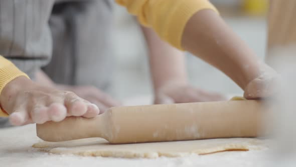 Girl Rolling Dough with Wooden Pin while Cooking with Grandma