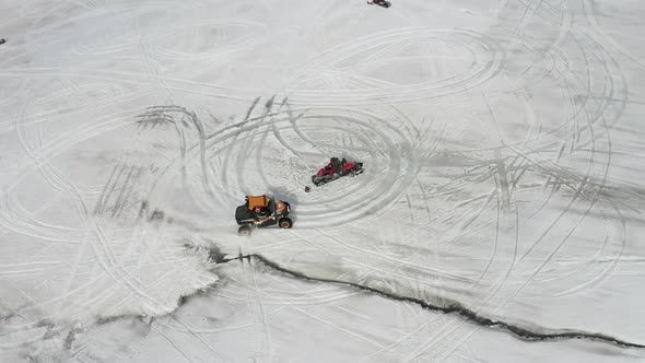 Snowmobile And Quadbike Drifting On Snowy Mountain of Langjokull In Iceland. - aerial pullback