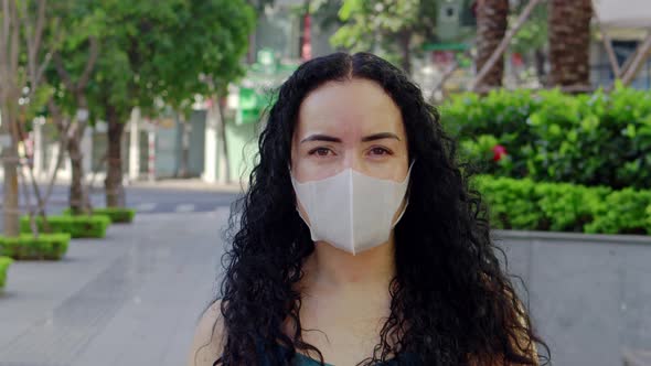 Closeup of an Adult Woman Wearing a Medical Mask Looking Around and Looking at the Camera on an