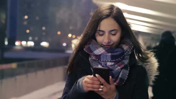 Girl Walking with Smartphone at Winter Subway Station 