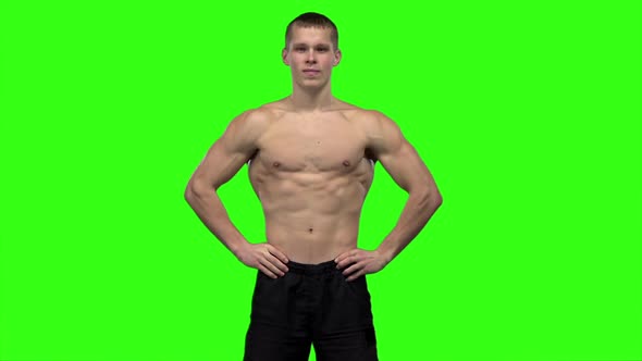 Man Strains the Muscles and Shows the Results of Training. Slow Motion. Green Screen