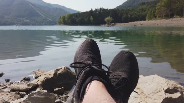 Man Enjoy Relax at Tranquil Lake Pov Shot of Shoes Panning Background