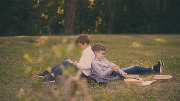 Schoolmates Tired of Preparing for Tests Sit on Fresh Lawn