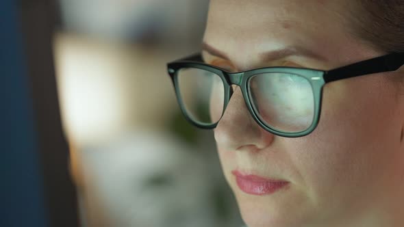 Woman in Glasses Looking on the Monitor and and Working with Charts and Analytics