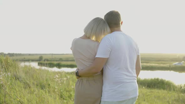 A Pair of Lovers Standing By the Lake Turned Away