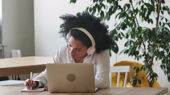 Portrait of African American Woman Talking on Video Conference Call Using Laptop and Headphones