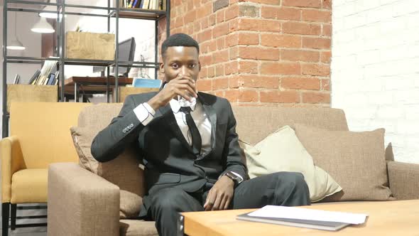 Black Businessman Drinking Water, Sitting in Office