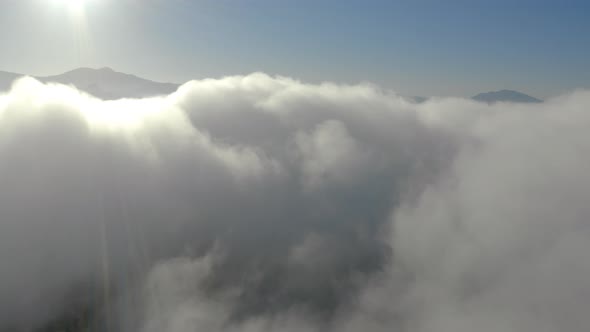 Aerial view of low fog over mountains in San Diego during sunrise