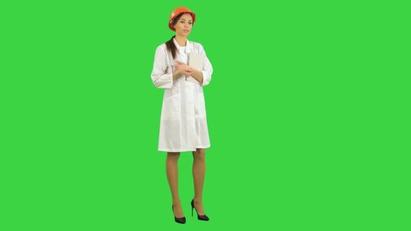 Female Construction Supervisor in Hardhat Holding Tablet Talking To Camera on a Green Screen