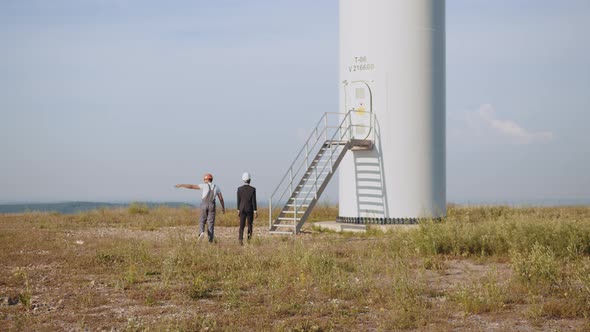 African American Inspector in Black Suit and White Helmet Talking with Indian