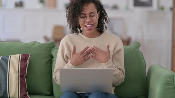 Online Video Call on Laptop By Young African Woman on Sofa 