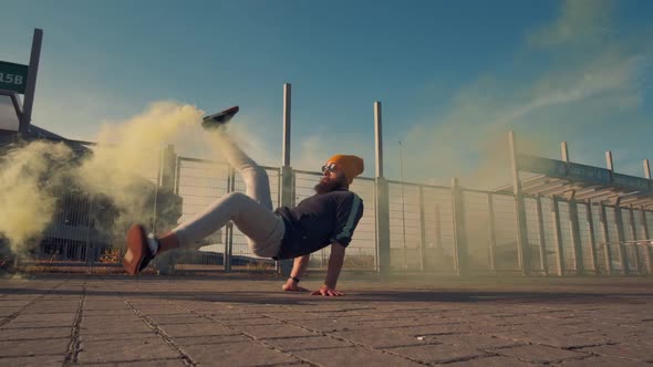 Portrait of a Hipster in Yellow Glasses. Dancing Street Dance with Orange Smoke. Slow Motion