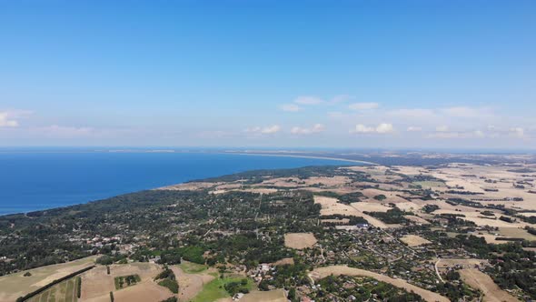 Aerial view of the coastline of Sejerøbugten with hills, fields and ocean.