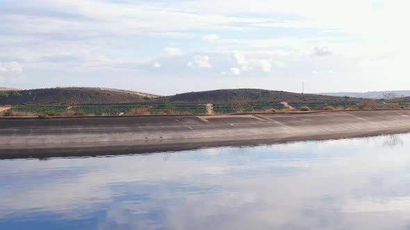 Drone Flying Over Water Reservoir To Reaveal Citrus Farm Fields In Spain.