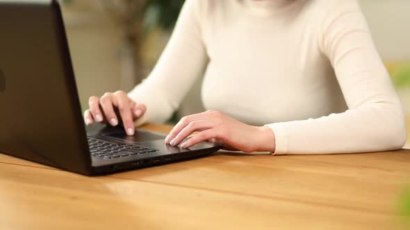 Close up female hands searching on laptop, woman working online,