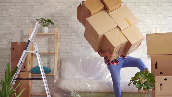 Man with Heavy Boxes in His Hands Loses His Balance and Falls on the Sofa Slow Mo