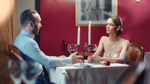 Fashionable Couple Smiling Talking at Dinner Date at Elegance Restaurant