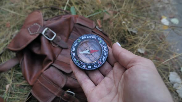 Female Hands Holding Compass and Looking for Direction of North