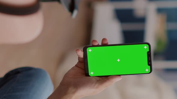 Closeup of Couple Holding Vertical Smartphone with Green Screen in Online Conference or Group Video