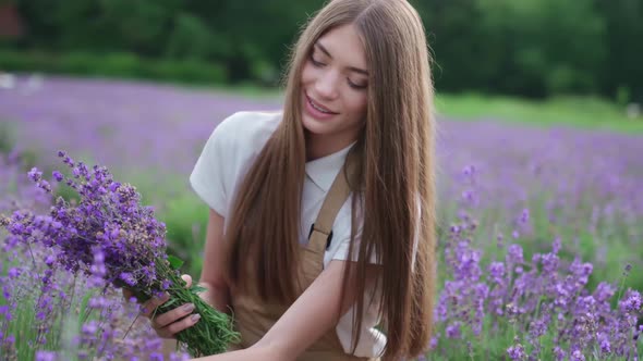 Happy Girl Making Lavender Bouquet in Field