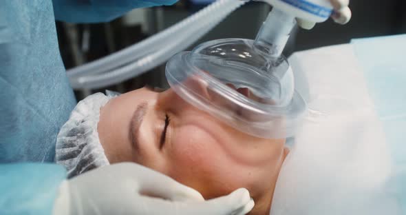 The Face of a Woman Patient with Closed Eyes with an Oxygen Mask on Her Face