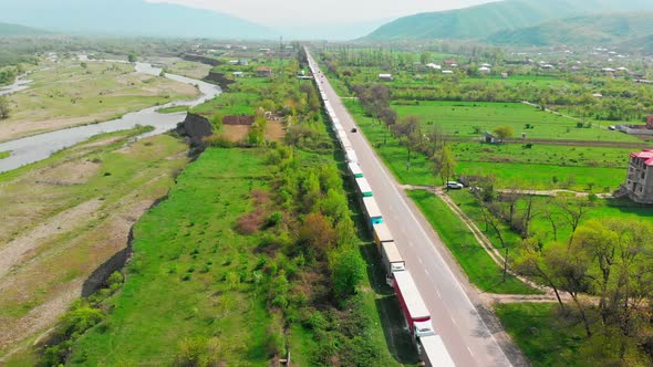 Highway In Caucasus Mountains With Hundreds Of Trucks Standing