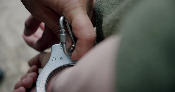 Criminals Take Off the Handcuffs on Hands Close Up.