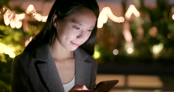 Business woman use of cellphone in city at night