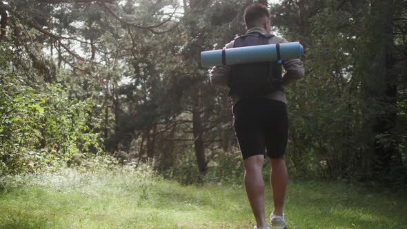 Happy Asian Man with Backpack Walking on Path Forest