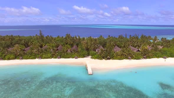 Aerial view of bungalow resort in the middle of forest, Maldives island.