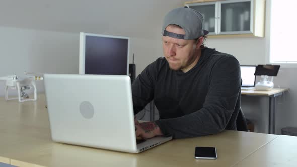 Man working in office with computers and aerial drone