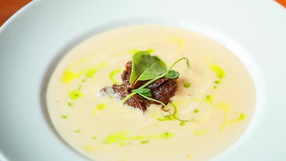Delicious cream soup with beef meat prepared for dinner in white plate