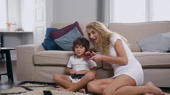 Woman with Long Curly Hair in White Dress Sitting on the Floor with Her Handsome Little Son