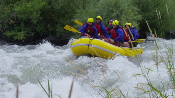 Group of people white water rafting in slow motion