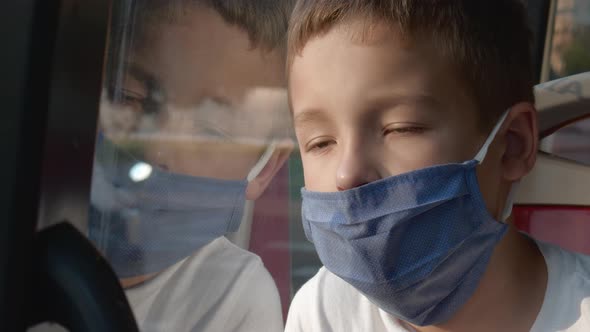 Tired of living with mask. Child in city bus