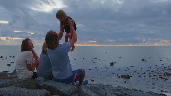 Happy Family on the Beach Watching the Sunset