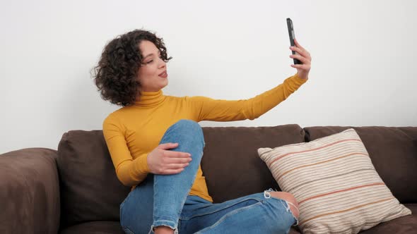 Smiling Hispanic Curly Woman Blogger Greets Talking Online Video Call Smartphone