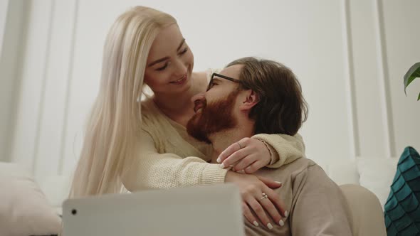 Adorable Millennial Couple Cuddling and Looking Each Other in the Eye Trustful and Happy