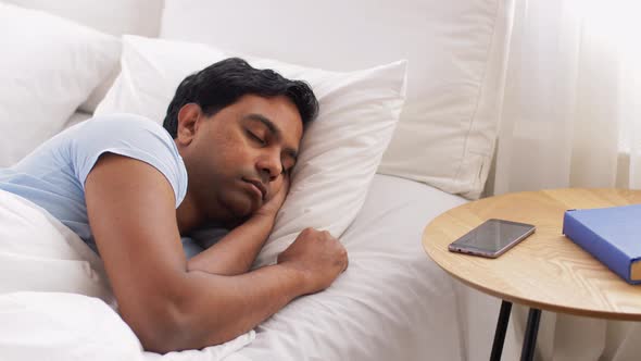 Man Looking at Smartphone and Goes Back To Sleep